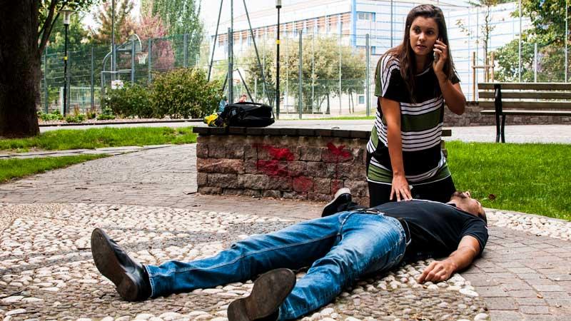 woman calling for help for man on ground